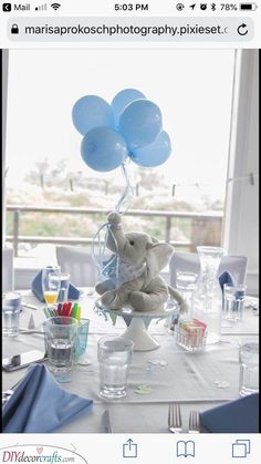 an elephant holding balloons on top of a table