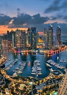 an aerial view of a city at night with boats in the water and lights on