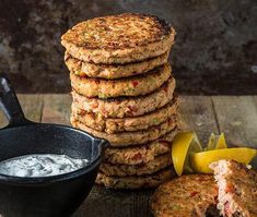 a stack of food sitting on top of a table next to a bowl of sauce