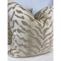 two zebra print pillows sitting on top of a bed