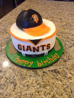 a birthday cake with a baseball cap on top and the name giants written on it