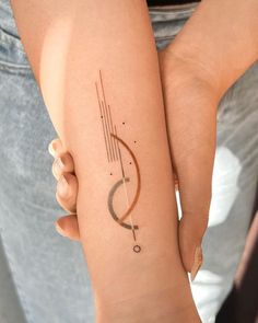 a woman's arm with a tattoo on it that has an arrow in the middle