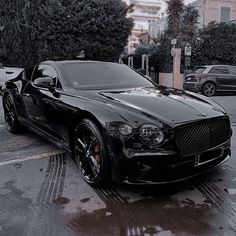 a black sports car parked on the side of the road in front of a building