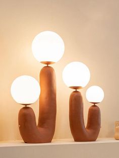 three lamps sitting on top of a shelf next to each other