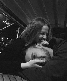 black and white photograph of a man hugging a woman's head on a bench