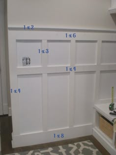 measurements for the door and shelves in a room with white painted wood paneling on the walls