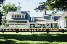 a large white house sitting on top of a lush green field