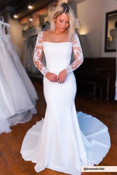 a woman in a white wedding dress looking down at the floor with her hands on her hips