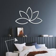 a bed sitting under a wall with a white flower decal on it's side