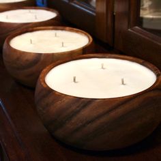 three wooden candles sitting on top of a counter next to a mirror and door frame