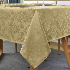 a table with a wine glass on it and a place setting in front of the table