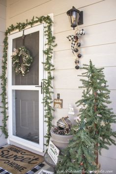 the front door is decorated for christmas with wreaths and pine cones on the tree