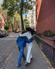 two women are walking down the street together