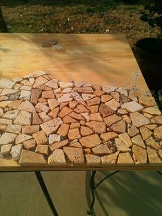 a wooden table topped with lots of small rocks on top of it's sides