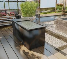 a bench sitting next to a potted plant on top of a wooden floor in front of a building