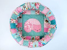 a pink and blue patchwork baby seat cushion