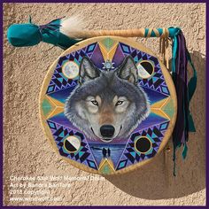 a wolf painted on a wooden plate with tassels around it's neck