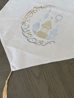 a white table cloth with an image of a castle on it and tassels