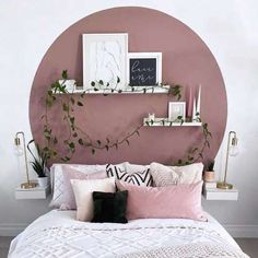 a black cat laying on top of a white bed next to a pink circle wall