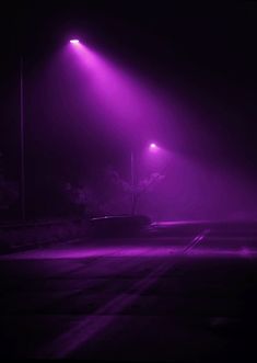 an empty parking lot at night with purple lights