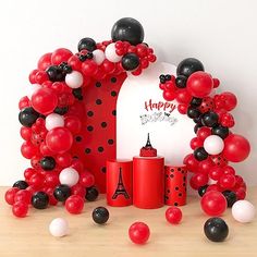 balloon arch with black, white and red balloons around it for a happy birthday party