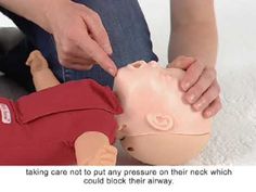 a person is holding the head of a dummy