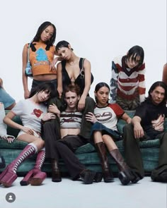 a group of young women sitting on top of a blue couch next to each other