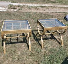 two wooden tables sitting on top of a grass covered field