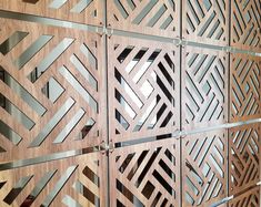 an intricate wooden wall with metal strips and geometric designs on the sides, as well as wood paneling