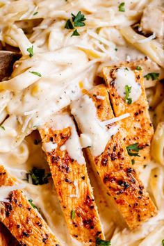 chicken parmesan pasta in a white bowl with a wooden spoon on the side