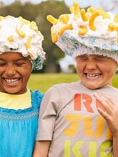 two young children wearing hats with doughnuts on their heads and smiling at the camera