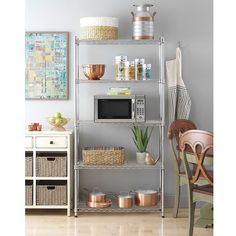 a kitchen shelving unit with pots and pans on the top shelf, next to a microwave