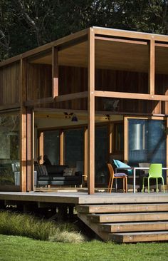 a wooden house sitting on top of a lush green field