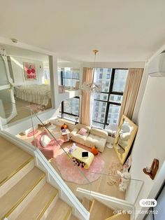 an aerial view of a living room with stairs leading up to the top floor and windows