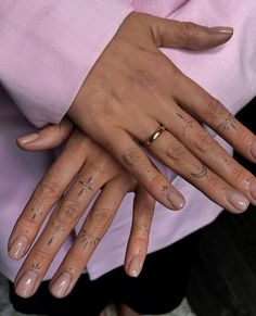 two people with their hands on each other's fingers, both wearing wedding rings