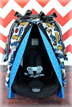 a baby car seat with blue and black bows on the front, attached to it's back