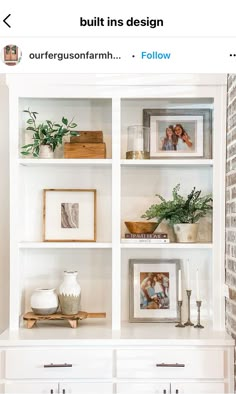 a white bookcase filled with pictures and other items on top of a brick wall