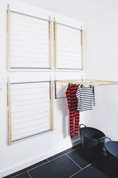 some clothes hanging on the clothes line in a room with black tile flooring and white walls