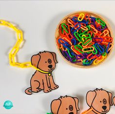 a wooden bowl filled with lots of colorful plastic letters next to cutouts of dogs