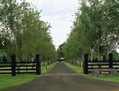 a gated driveway leading into a lush green park