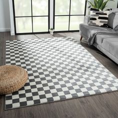 a living room with a checkered rug on the floor next to a gray couch