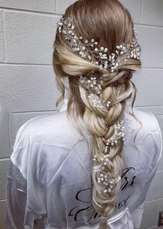 a woman with long blonde hair wearing a braid and flowers in it's hair