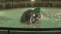 two people are in the water and one is holding another person's head while they both have green hair