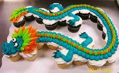 cupcakes decorated with blue and orange icing are sitting on a white surface