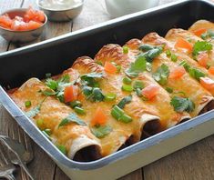 a casserole dish with meat and vegetables in it sitting on a wooden table