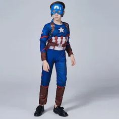 a young boy dressed as captain america standing in front of a gray background with his hands on his hips