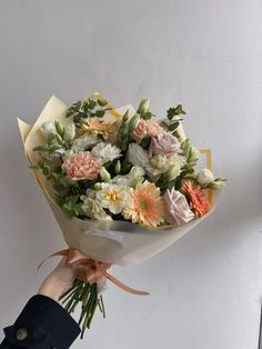 a person holding a bouquet of flowers in their hand