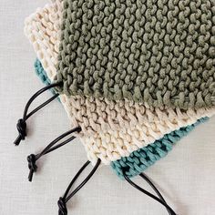 three crocheted pieces of cloth laying on top of each other