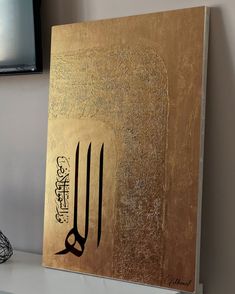 an arabic calligraphy is displayed on a shelf