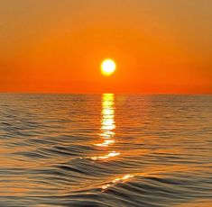 the sun is setting over the ocean as it reflects in the water's surface